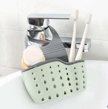 Adjustable rubber sink drainer basket in kitchen holding sponges and dishcloths for quick drying and storage