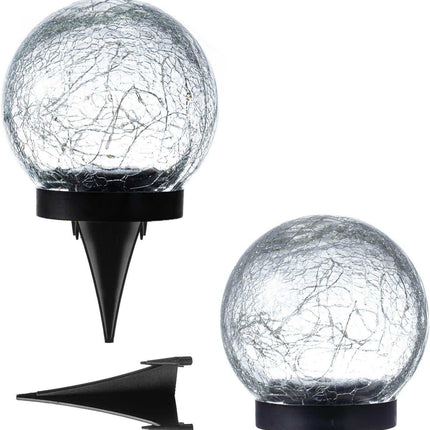 Solar crackle ball light glowing warmly in garden at night powered by solar panel