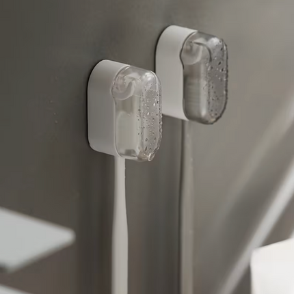 Plastic wall-mounted toothbrush holder by UK Dropships, dustproof bathroom organizer with no-drill installation and portable storage box.