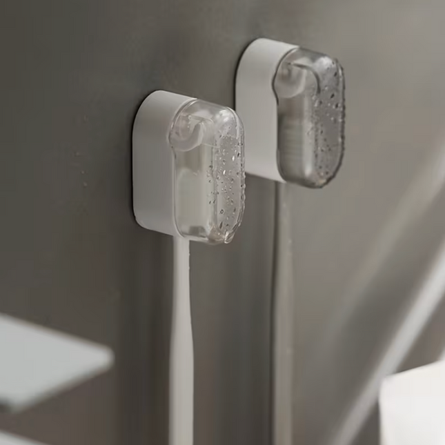 Plastic wall-mounted toothbrush holder by UK Dropships, dustproof bathroom organizer with no-drill installation and portable storage box.