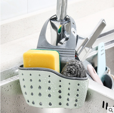 Adjustable rubber sink drainer basket hanging in kitchen with colorful sponges and dishcloths for efficient storage and quick drying