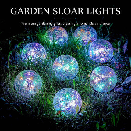 Solar crackle ball light glowing in garden at night with warm yellow LED copper wire lamps