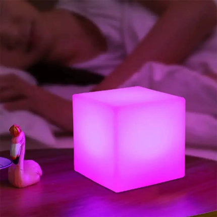 Rechargeable cube LED stool table with remote control displaying multicolor lighting options in modern room setting