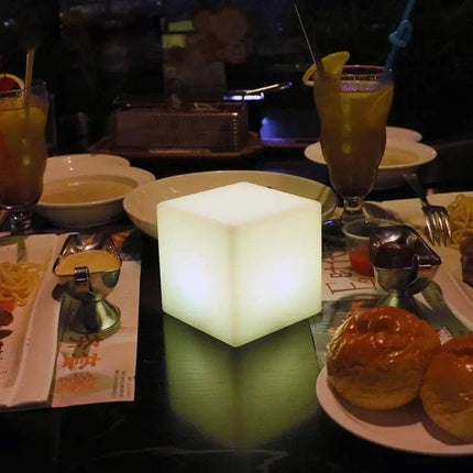 Rechargeable Cube LED stool table glowing with multicolor lights and remote control on a patio setting