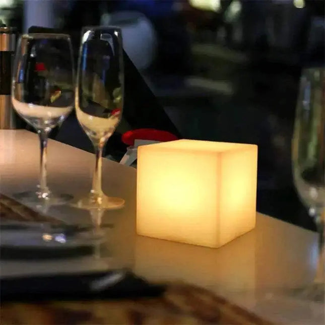 Rechargeable cube LED stool table with remote control and multicolor lighting in a modern indoor setting